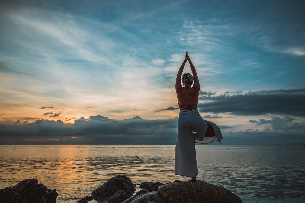 imagen de mujer en pose yoga en la playa